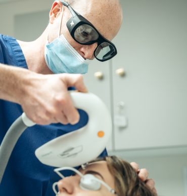 doctor doing a laser treatment on forehead
