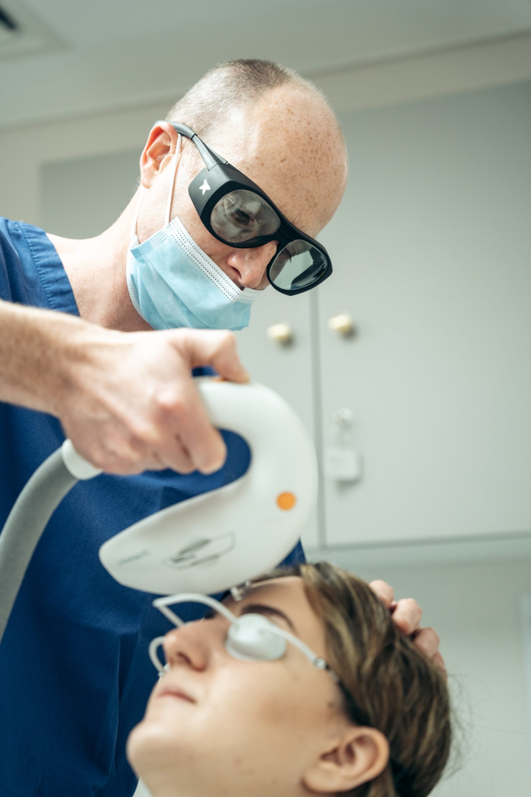 doctor doing a laser treatment on forehead