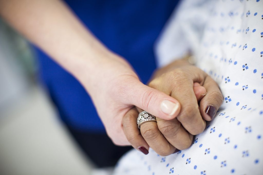 doctor holding patient's hand