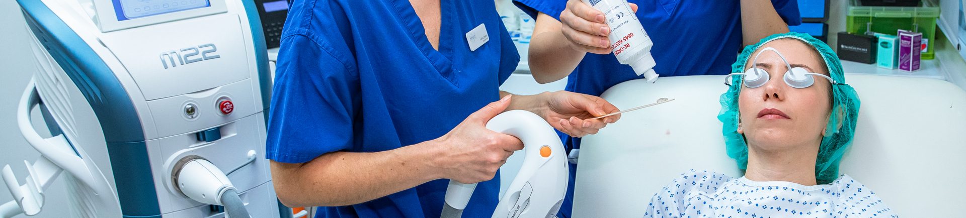 woman patient receiving laser treatment by two doctors