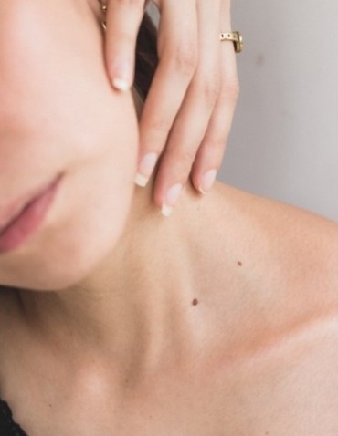 woman touching her neck, close-up