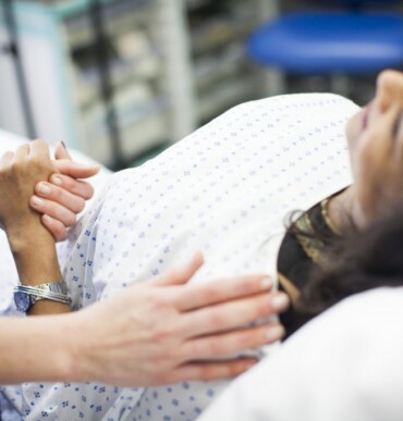 doctor comforting patient by holding her hand