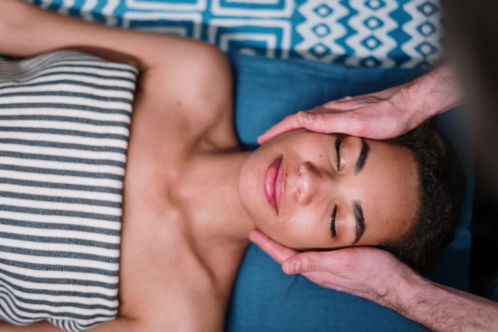woman patient smiling while doctor holding her head
