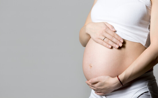 Young pregnant woman touching her belly