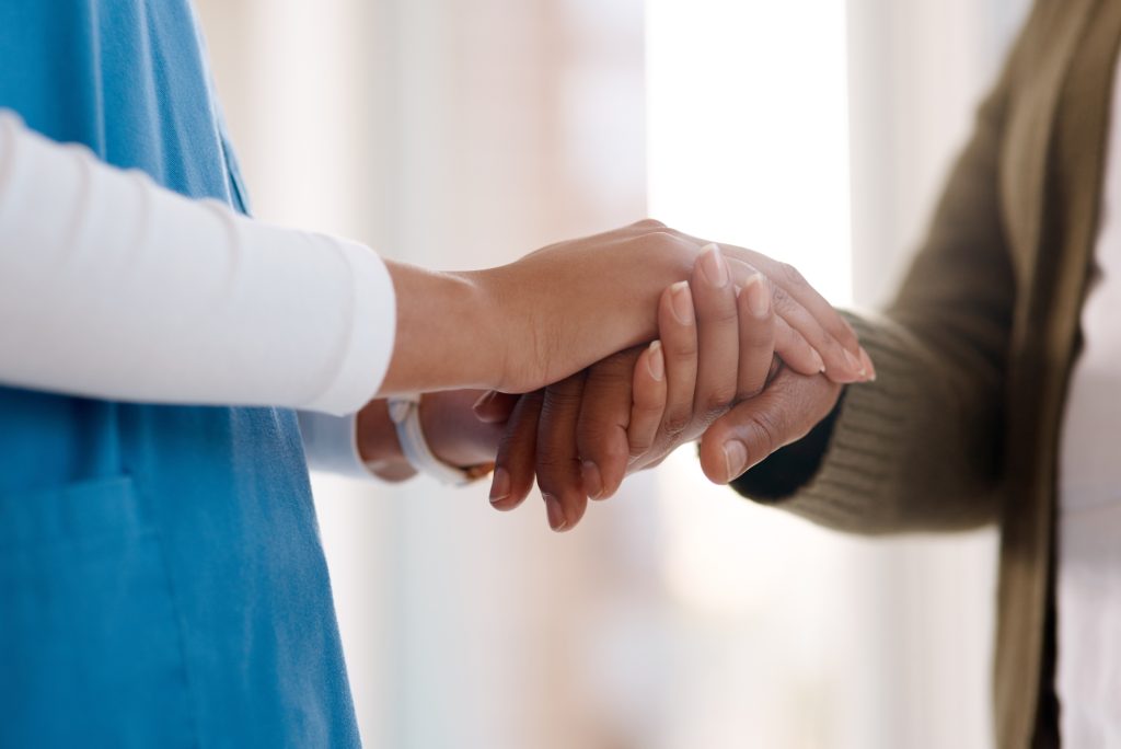 Woman, holding hands or consulting a caregiver for support or empathy for healthcare service.